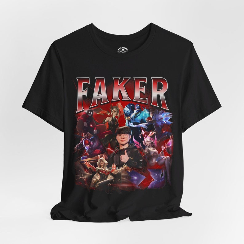 Op de afbeelding: Zwart T-shirt met een grafische print van een videogamepersonage, "Faker", omringd door andere personages. De tekst "Faker" staat in grote witte letters.