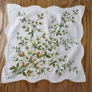 May include: A white cotton handkerchief with a scalloped edge and a floral design in shades of green, brown, and white.