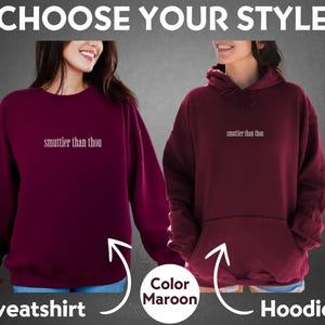 Puede incluir: Sudadera y sudadera con capucha color granate con el texto "smuttier than thou" en blanco. La imagen muestra dos opciones: una sudadera de cuello redondo y una sudadera con capucha. El texto "Choose Your Style" est&aacute; en la parte superior.