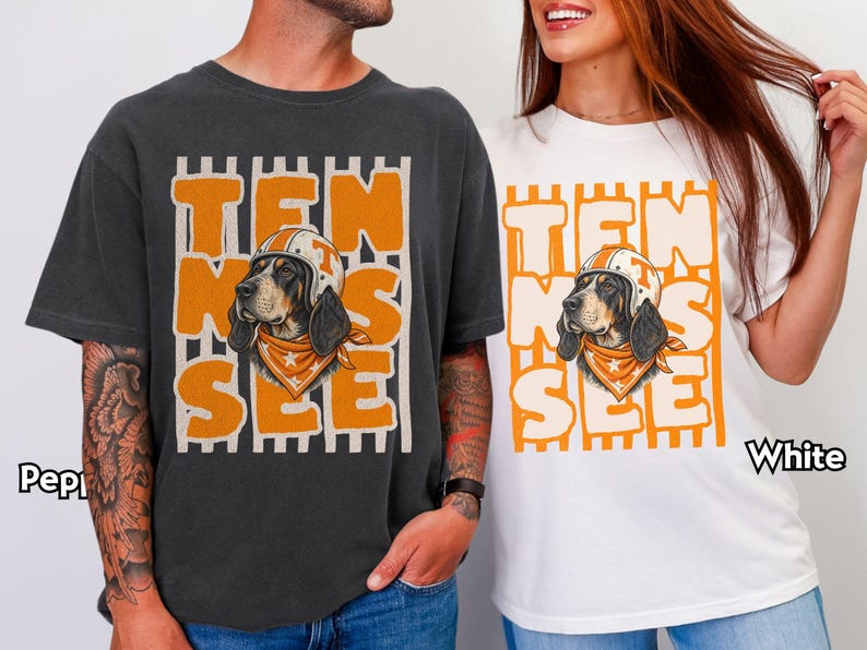 May include: A charcoal grey t-shirt and a white t-shirt, each featuring a graphic of a dog wearing a helmet and bandana, with the orange text "TEN SEE" layered over vertical stripes. The shirts are labelled "Pepper" and "White" respectively.
