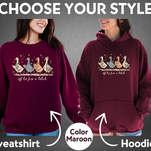 May include: A maroon sweatshirt and hoodie are displayed, each featuring a whimsical illustration of geese. The design includes the text "off to fix a latch." The image also includes the text "Choose Your Style" and "Color Maroon."