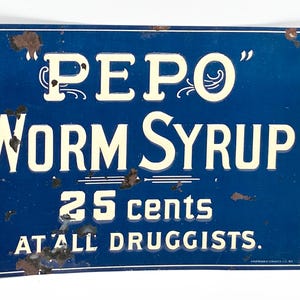 May include: A white ceramic mug with a black handle and the text "But First, Coffee" in a bold, black font. The mug is set against a blurred background, suggesting a cozy setting.