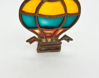Portavelas vintage de latón y vitral con forma de globo aerostático de la marca Enesco, 1989.