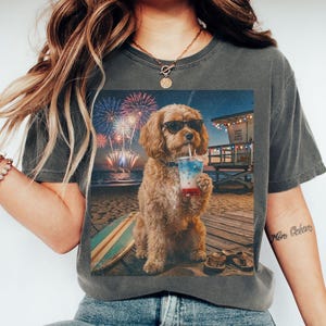 May include: Dark grey t-shirt with a graphic of a dog wearing sunglasses, drinking a beverage on a beach with fireworks. The word "PEPPER" is printed at the bottom of the shirt.