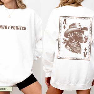 May include: White sweatshirt with the text "HOWDY POINTER" in brown on the front. The back features a brown graphic of a dog wearing a cowboy hat and bandana, inside a playing card design with the Ace of Diamonds and Ace of Hearts.