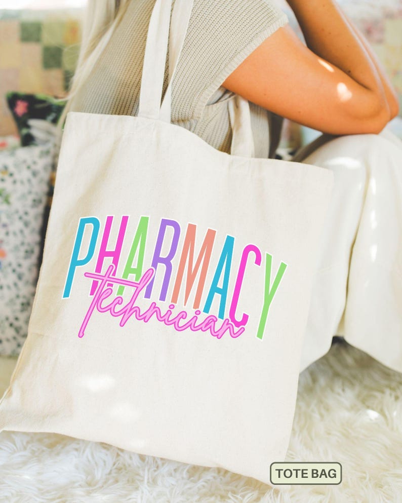 May include: Cream-colored tote bag with the words "PHARMACY Technician" in colorful, vertical text. The text is in shades of blue, green, pink, purple, and orange. The bag has two handles and a small tag that says "TOTE BAG".