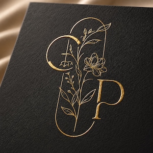 May include: A black textured card featuring a gold foil embossed design. The graphic consists of the letters C and P integrated with a delicate line art illustration of a flowering plant, enclosed within a thin, rounded vertical frame.