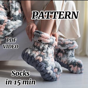 Peut inclure: Chaussettes tricotées à la main dans des tons de gris, de rose et de blanc. Les chaussettes sont épaisses et duveteuses, avec un revers. Le texte "PATTERN", "PDF VIDEO" et "Socks in 15 min" est inclus.