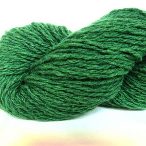 May include: A skein of dark green yarn, made of wool, is shown in a close-up view. The yarn is soft and fluffy, and it is perfect for knitting or crocheting.