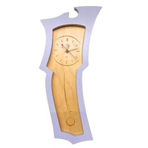 May include: A unique wall clock with a light wood face and a light purple frame. The clock has a pendulum design and red clock hands. The clock face has a decorative design at the top. The clock is approximately 30 inches tall.