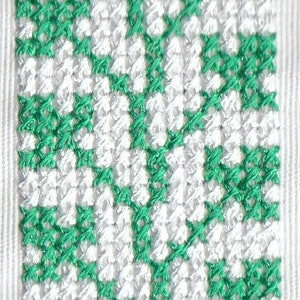 Puede incluir: Una tela blanca con un patrón de cuadros verde y blanco. El patrón se crea con pequeños cuadrados tejidos.