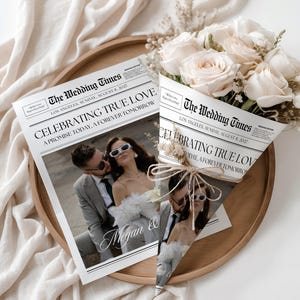 Op de afbeelding: Een trouw-krant met de kop "CELEBRATING TRUE LOVE" en een foto van een stel met zonnebrillen. Een boeket witte rozen ligt naast de krant op een houten dienblad.