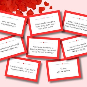 Könnte beinhalten: Eine Sammlung rot umrandeter Karten mit romantischen Botschaften, darunter Sätze wie „Wie konnte ich so viel Glück haben, dich zu finden?“ und „Du bist perfekt.“ Rote herzförmige Konfetti sind verstreut.