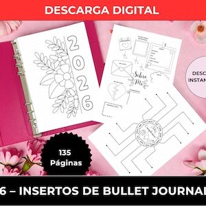 May include: A pink A5 bullet journal with inserts. The journal is open, revealing pages with floral designs and the year 2026. Additional inserts include templates for journaling, with the text "DESCARGA DIGITAL" and "DESCARGA INSTANTÁNEA". The journal has 135 pages.