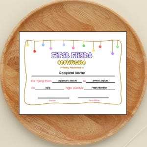 May include: A printable first flight certificate with a colorful garland design. The certificate has spaces to fill in the recipient's name, departure and arrival airports, date, and flight number.