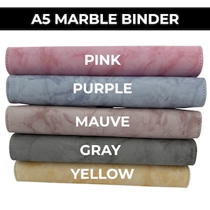 May include: A stack of A5 marble binders in various colors: pink, purple, mauve, gray, and yellow. Each binder has a marbled texture and the color name is printed in white on the front.