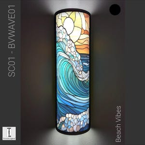 Può includere: Un paralume cilindrico in vetro colorato con un design a onde blu, verde e bianco e una scena di tramonto giallo e arancione. Il paralume è etichettato "Beach Vibes" e "SC01 - B WAVE01".