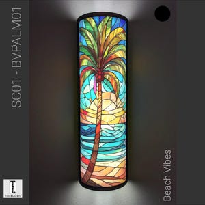 Può includere: Un paralume in vetro colorato con una scena di palma e tramonto. Il paralume è cilindrico e ha una cornice in metallo nero. Il testo "Beach Vibes" è scritto verticalmente sul lato destro dell'immagine. Il testo "SC01 - BV PALM01" è scritto verticalmente sul lato sinistro dell'immagine.