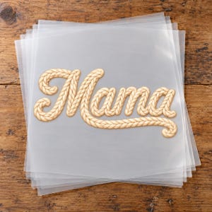 May include: A stack of translucent plastic sheets featuring the word Mama in a beige, rope-textured script font. The letters are connected with a braided rope design, creating a tactile appearance on the smooth, semi-transparent surface.