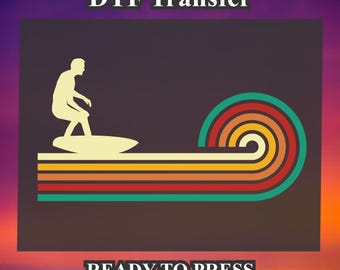 May include: A silhouette of a person surfing on a wave with a retro design. The wave is made up of colorful stripes in shades of orange, yellow, red, and green. The text "DTF Transfer" and "READY TO PRESS" is included in the image.