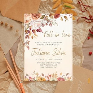 May include: A bridal shower invitation with the text "Fall in love" and "Juliana Silva." The design features watercolor flowers, pumpkins, and leaves in autumnal colors. The invitation includes the date, time, and location of the event.