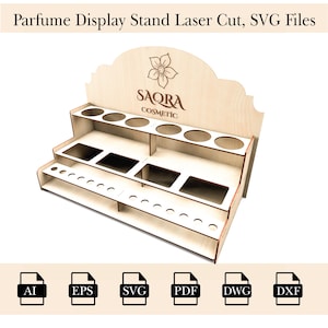 May include: A wooden display stand for perfume bottles. The stand has three shelves and a sign that says "SAQRA COSMETIC".