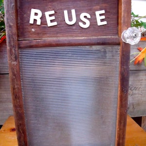 May include: A wooden box with a glass pane door and a white knob. The box has the word "REUSE" written on the front.