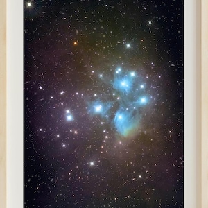 May include: A photograph of a star cluster in space. The cluster is surrounded by a blue and green nebula. The stars are bright and white against the dark background of space.