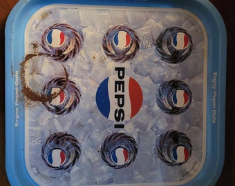 May include: Blue metal tray with a Pepsi logo and the text "Enjoy Pepsi-Cola" repeated around the edge. The tray features a design of ice cubes and Pepsi bottle caps.
