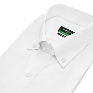 Op de afbeelding: Wit overhemd met knopen en een knoopsluiting. Het shirt heeft een label met de tekst "John Clothier London Green Label 100% Katoen".