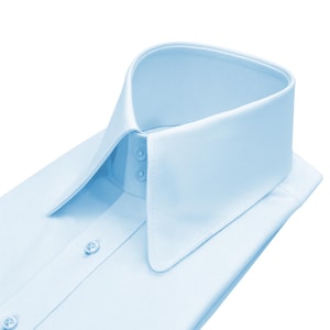 Può includere: Una camicia azzurra con colletto alto e a punta. La camicia ha un design classico con bottoni con tre bottoni sui polsini e due sul colletto. Il tessuto appare liscio e senza pieghe.