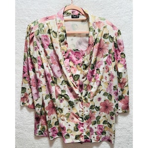 Blusa Lynn B con estampado floral, mangas tres cuartos y detalles de perlas.