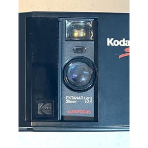Cámara de película Kodak Serie S de 35 mm de los años 80 con lente Ektanar, enfoque automático y flash, con estuche.