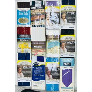 Könnte beinhalten: Eine Sammlung von Nähzubehör, darunter Schrägband, Saumband und Nahtband. Die Packungen sind in verschiedenen Farben wie Blau, Lila und Schwarz erhältlich und tragen die Marken "Wrights" und "Talon". Maße in Yards.