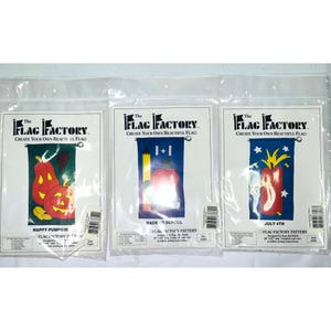 May include: Three packaged flag patterns from The Flag Factory. Designs include a pumpkin scene with the text "Happy Pumpkin", a school-themed design with an apple and pencil, and a July 4th design with fireworks.