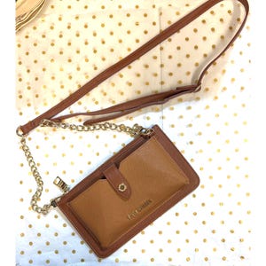 May include: A brown and tan crossbody wallet with a gold chain strap. The wallet has a snap closure and a zipper pocket. The brand name "STEVE MADDEN" is printed on the front.