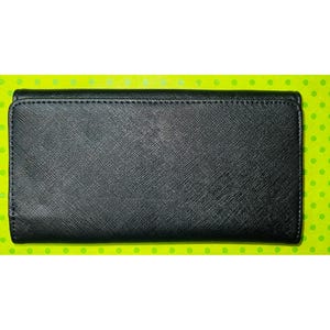 May include: A black wallet with a textured surface. The wallet is rectangular and has a flap closure. The background is a bright green with small yellow polka dots.