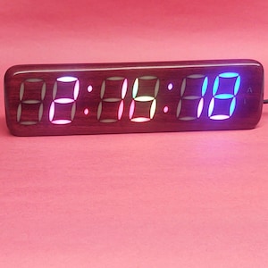 Puede incluir: Un reloj de madera con una pantalla digital roja, blanca y azul que muestra la hora 00:00:00.