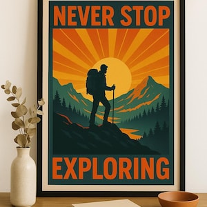 May include: A framed poster with the words "NEVER STOP EXPLORING" in orange text. The image depicts a hiker silhouetted against a sunset over mountains. The poster is in a black frame and sits on a wooden surface.