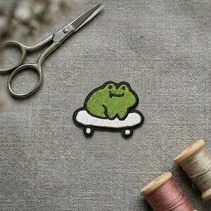 Écusson thermocollant brodé grenouille sur planche à roulettes : appliqué kawaii