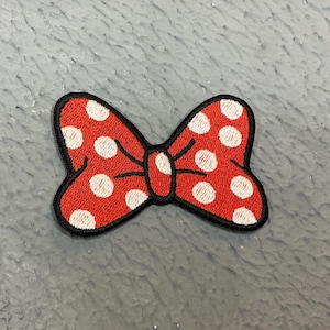 Peut inclure: Noeud rouge à pois blancs avec un contour noir.