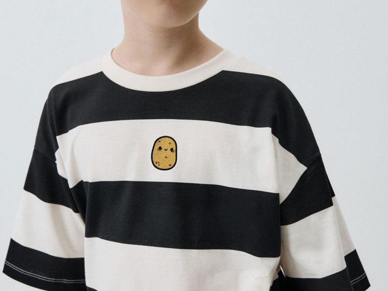 Op de afbeelding: Zwart-wit gestreept T-shirt met een schattige aardappelafbeelding. De top met korte mouwen heeft een ronde hals en een losse pasvorm. De aardappelafbeelding is op de voorkant geborduurd.