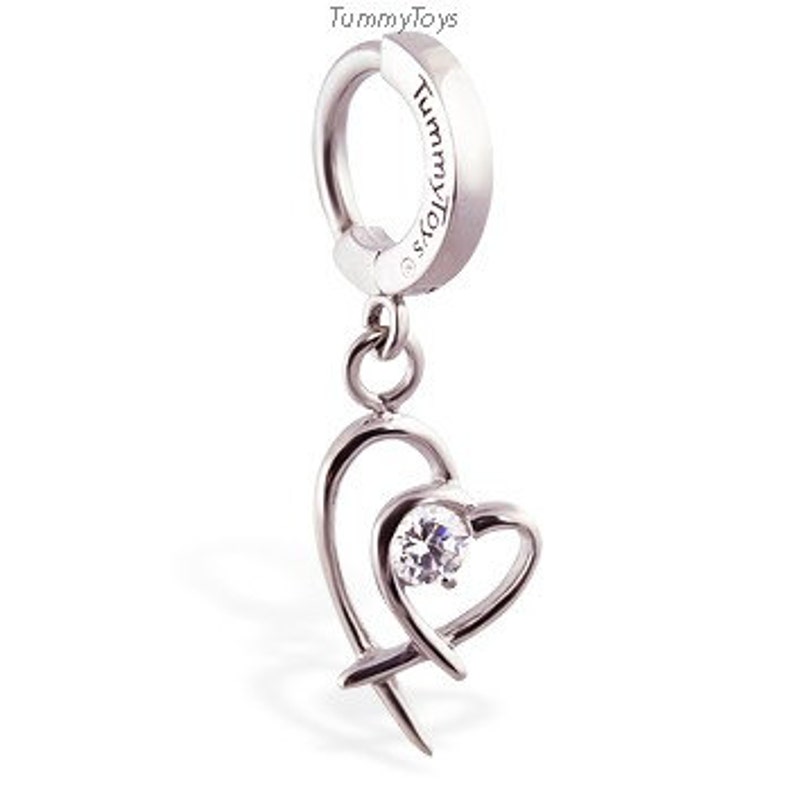 Puede incluir: Piercing corporal de plata con un colgante de coraz&oacute;n con un cristal transparente. El coraz&oacute;n est&aacute; formado por dos bucles entrelazados.