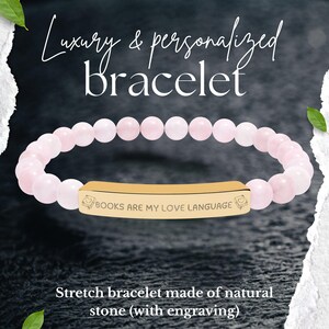 Könnte beinhalten: Ein rosafarbenes, dehnbares Armband mit Perlen und einem goldfarbenen, rechteckigen Mittelstück. Das Mittelstück ist mit den Worten "BOOKS ARE MY LOVE LANGUAGE" graviert. Das Armband besteht aus Naturstein. Der Text auf dem Bild lautet "Luxus & personalisiertes Armband".