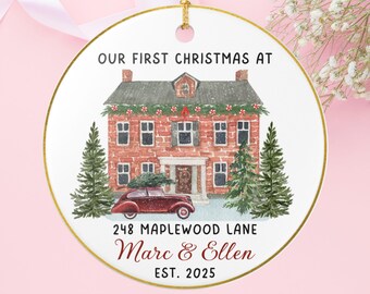 May include: A circular Christmas decoration with a gold edge and hanging loop. It displays a watercolour illustration of a brick house, a vintage car with a Christmas tree, and the text "OUR FIRST CHRISTMAS AT 248 MAPLEWOOD LANE Marc & Ellen EST. 2025."