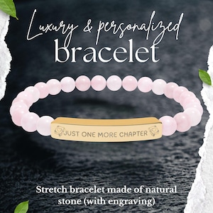 Könnte beinhalten: Ein Stretch-Armband aus rosa Natursteinperlen. Das Armband hat einen goldfarbenen Balken mit der Gravur "JUST ONE MORE CHAPTER". Das Bild enthält auch den Text "Luxury & personalized bracelet".