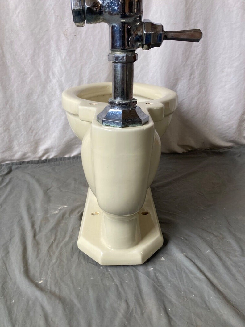 May include: A vintage off-white toilet bowl with a chrome flush valve and handle.