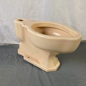 May include: A vintage, off-white toilet bowl with a rounded bowl and a pedestal base. The toilet is made of ceramic and has a smooth, glossy finish.