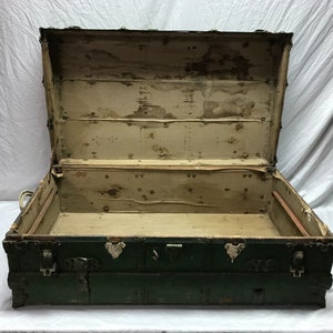 May include: A vintage green wooden trunk with metal hardware and a worn interior. The trunk is open and empty, revealing the wooden interior.
