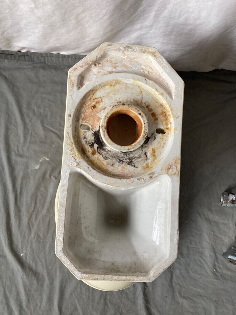 May include: A white porcelain toilet bowl with a round opening and a rectangular base. The bowl is designed for a wall-mounted installation.